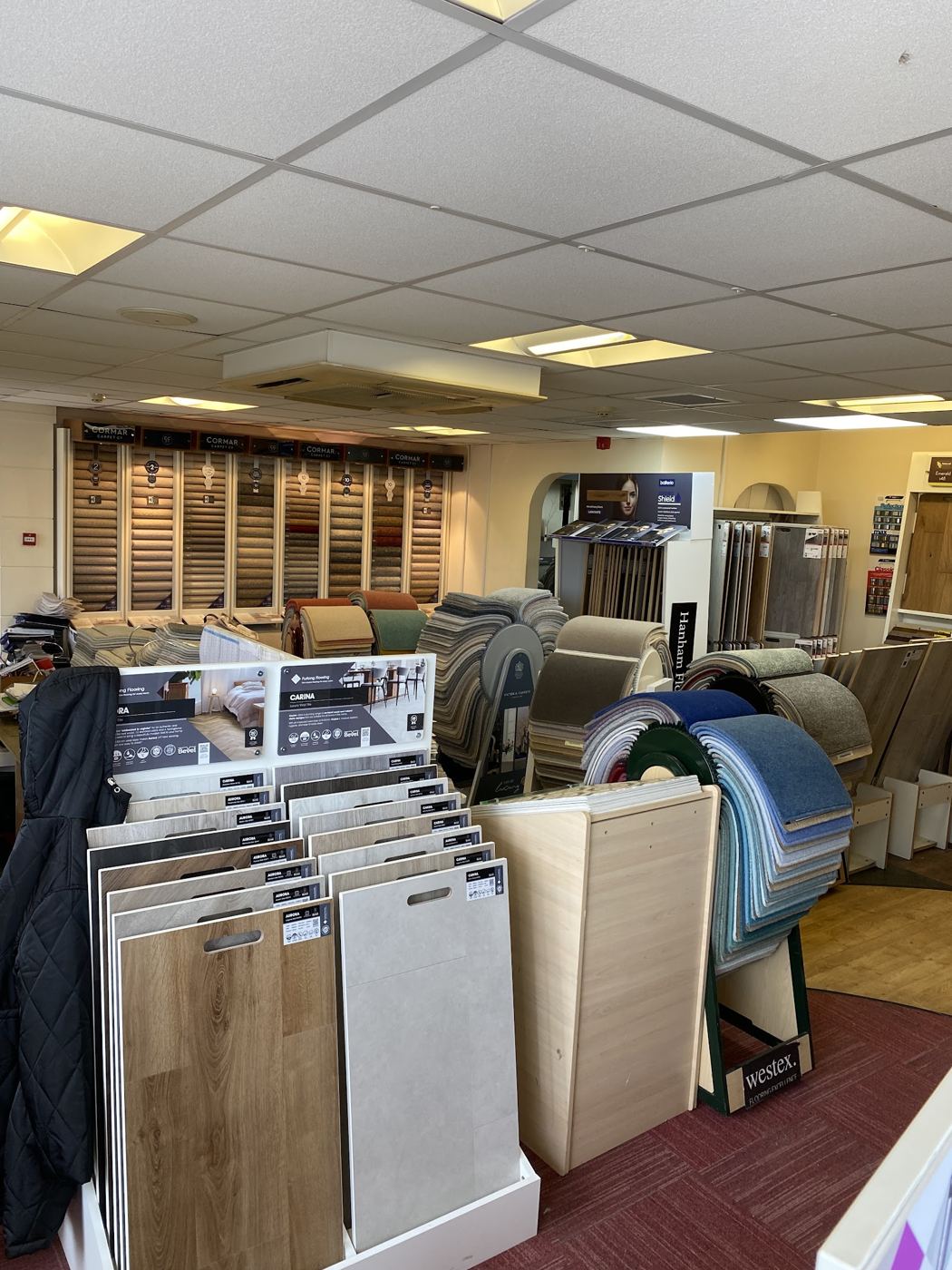 Inside the showroom on Hanham High Street: carpet rolls, sample stands and wood-look boards