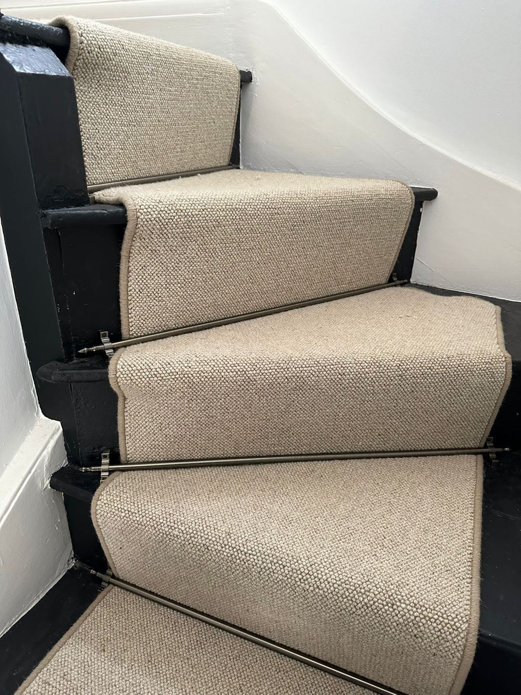 Wool-look runner on curved winding stairs with black edges
